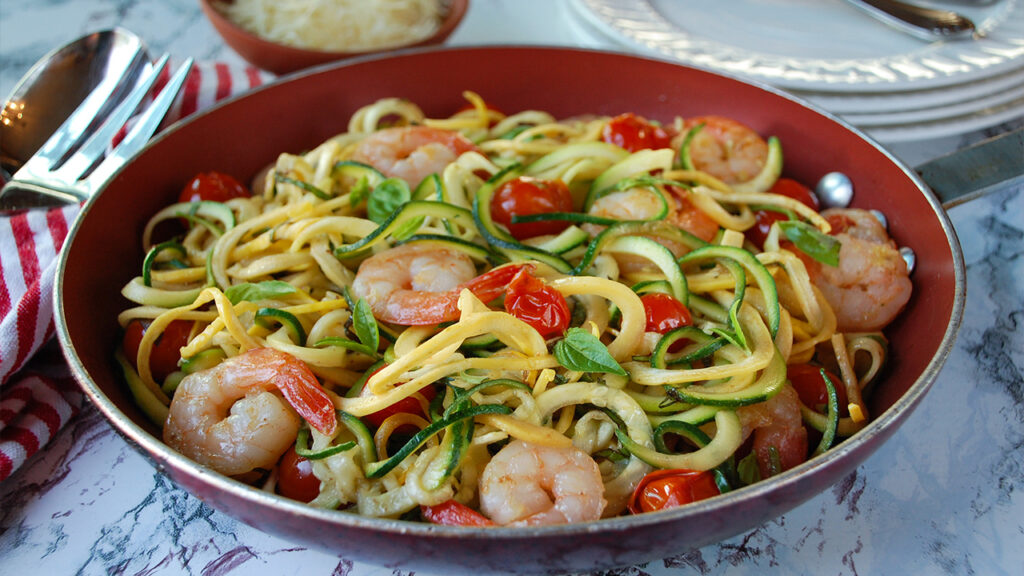 Shrimp zucchini noodle stir-fry with cherry tomatoes and basil.