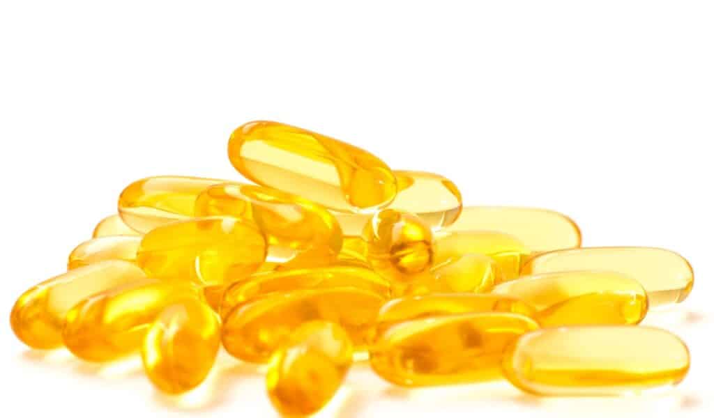 Fish Oil Nutrition: Clear gel capsules filled with golden liquid arranged on a white background.